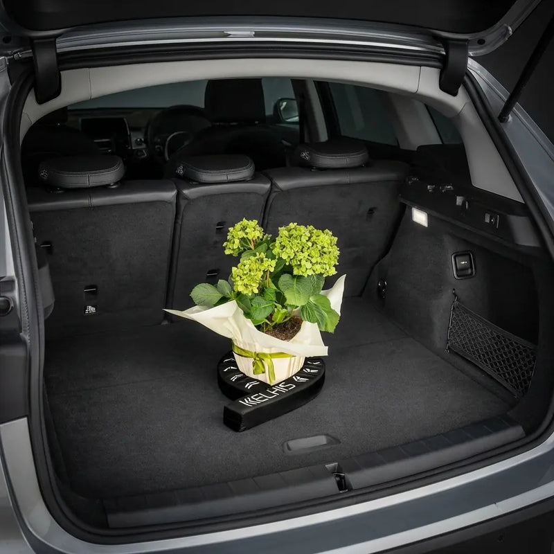 FlexiStick wrapping around a tall potted plant in a car trunk