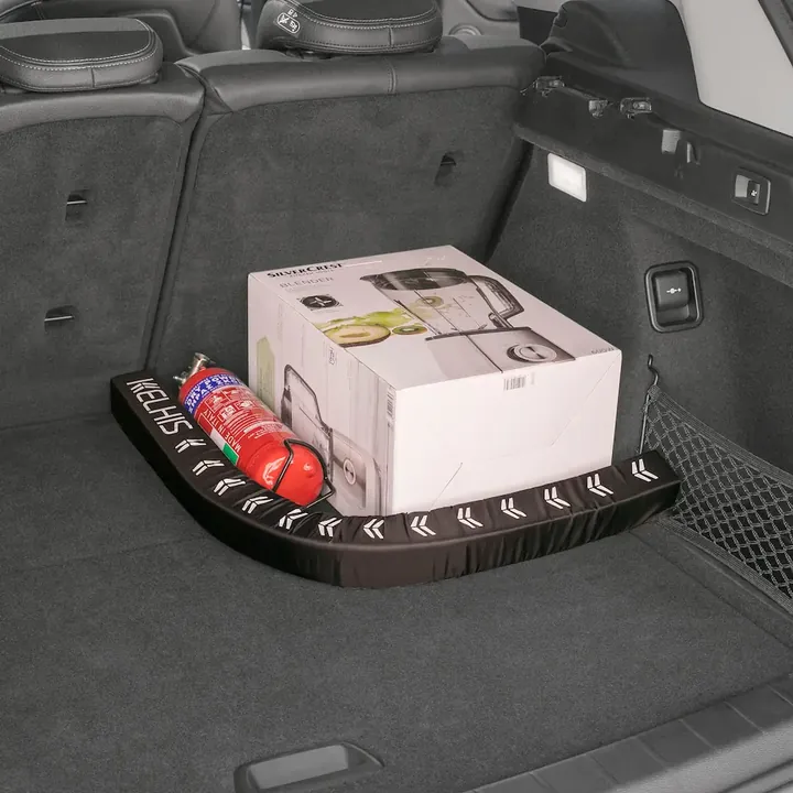 FlexiStick bent around a large box and a fire extinguisher in the corner of the trunk