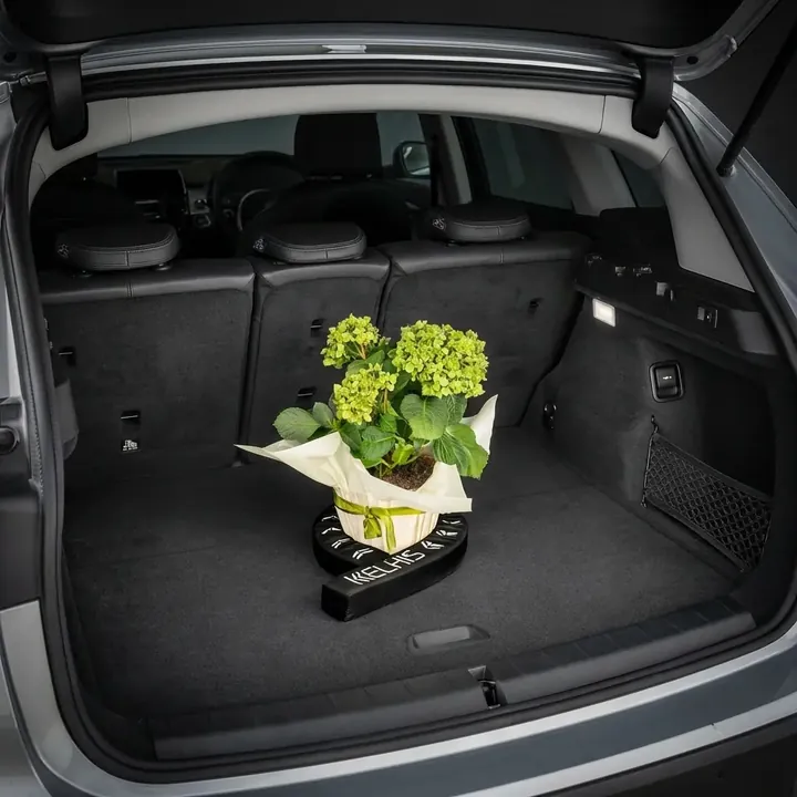 FlexiStick wrapping around a tall potted plant in a car trunk